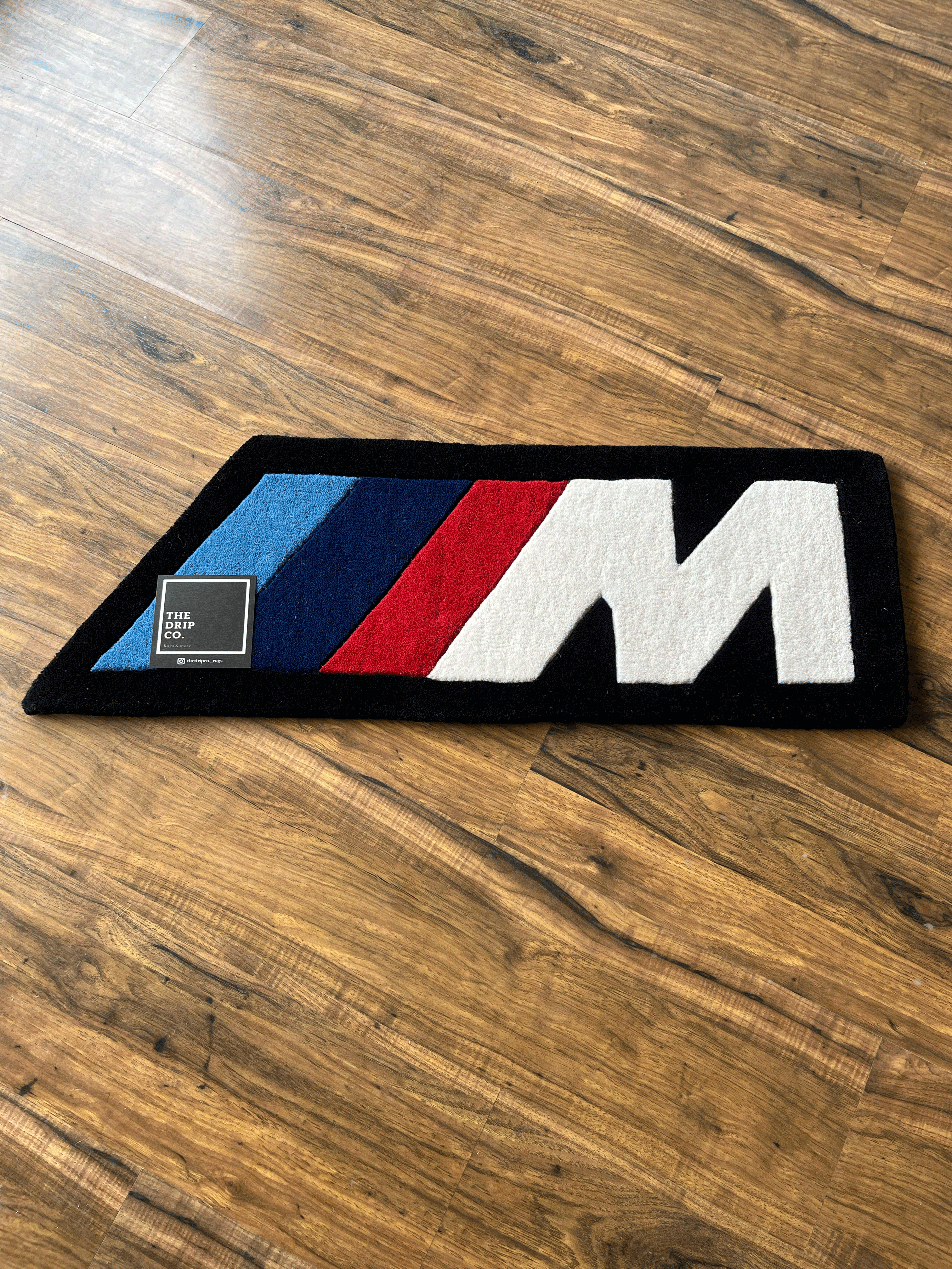 M speed  racing Rug by The Drip Co.